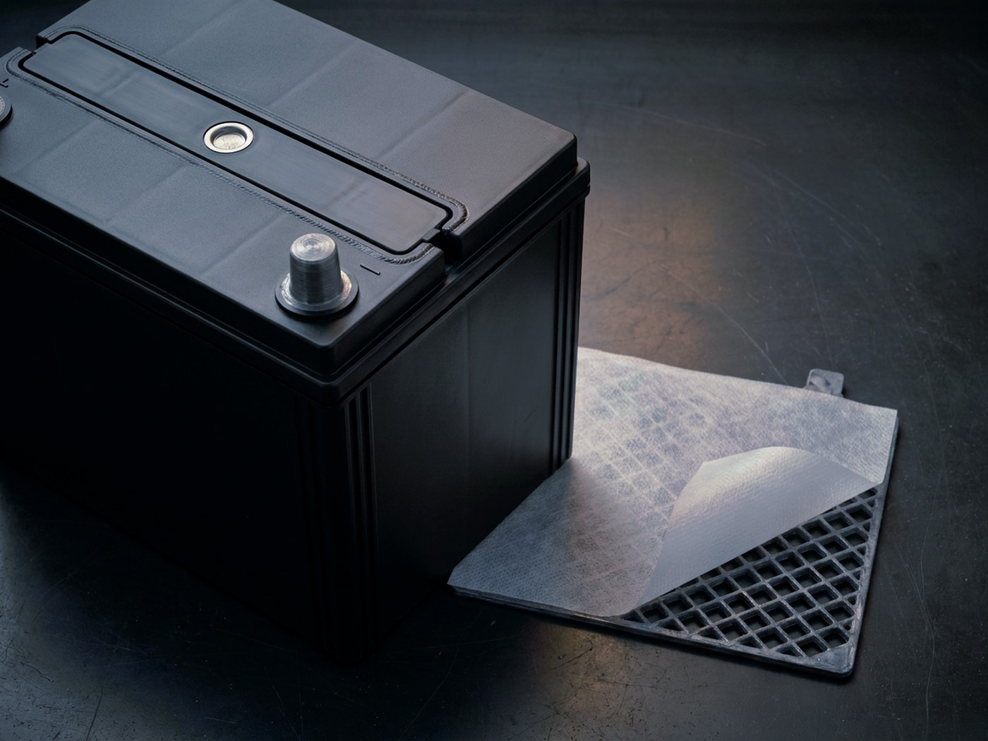 Sealed battery lid with a labyrinth venting channel and a lead plate under a polyester scrim